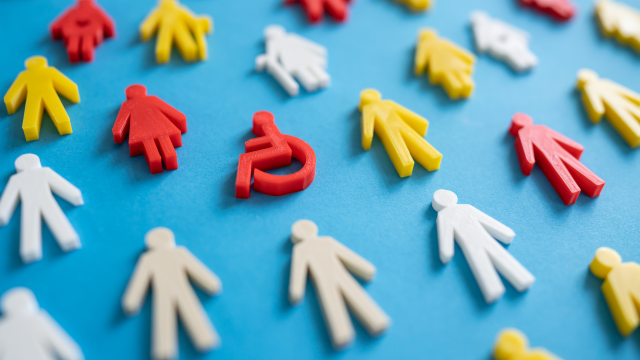 Image shows plastic peg people in various colours, and genders and some carry canes while others are in a wheelchair.